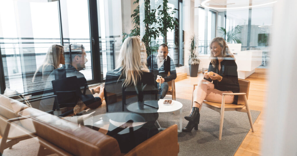 Employees gathered around a table for a meeting in a coworking space