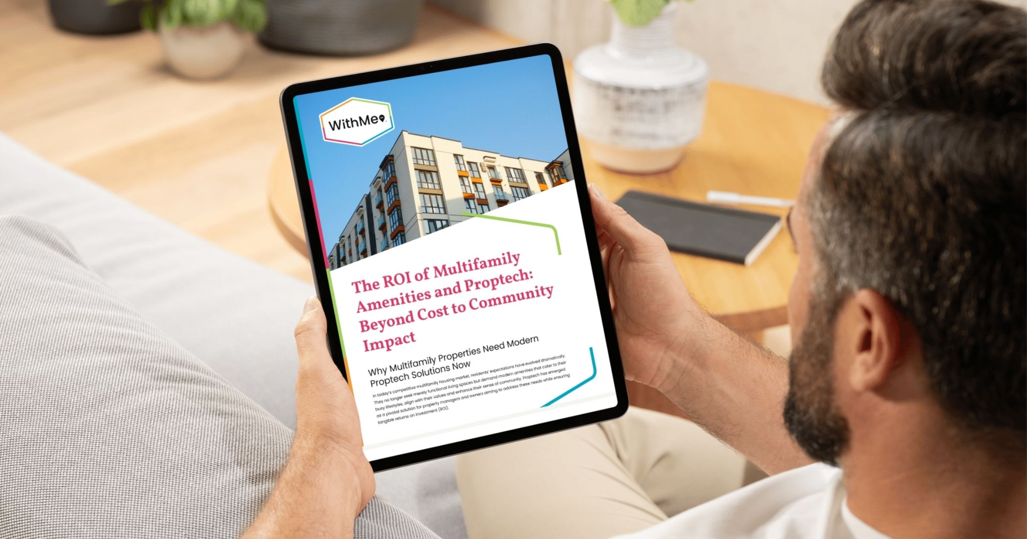 Person holding a tablet displaying an ebook titled "The ROI of Multifamily Amenities and Proptech: Beyond Cost to Community Impact" by WithMe, highlighting the importance of modern PropTech solutions for multifamily properties.