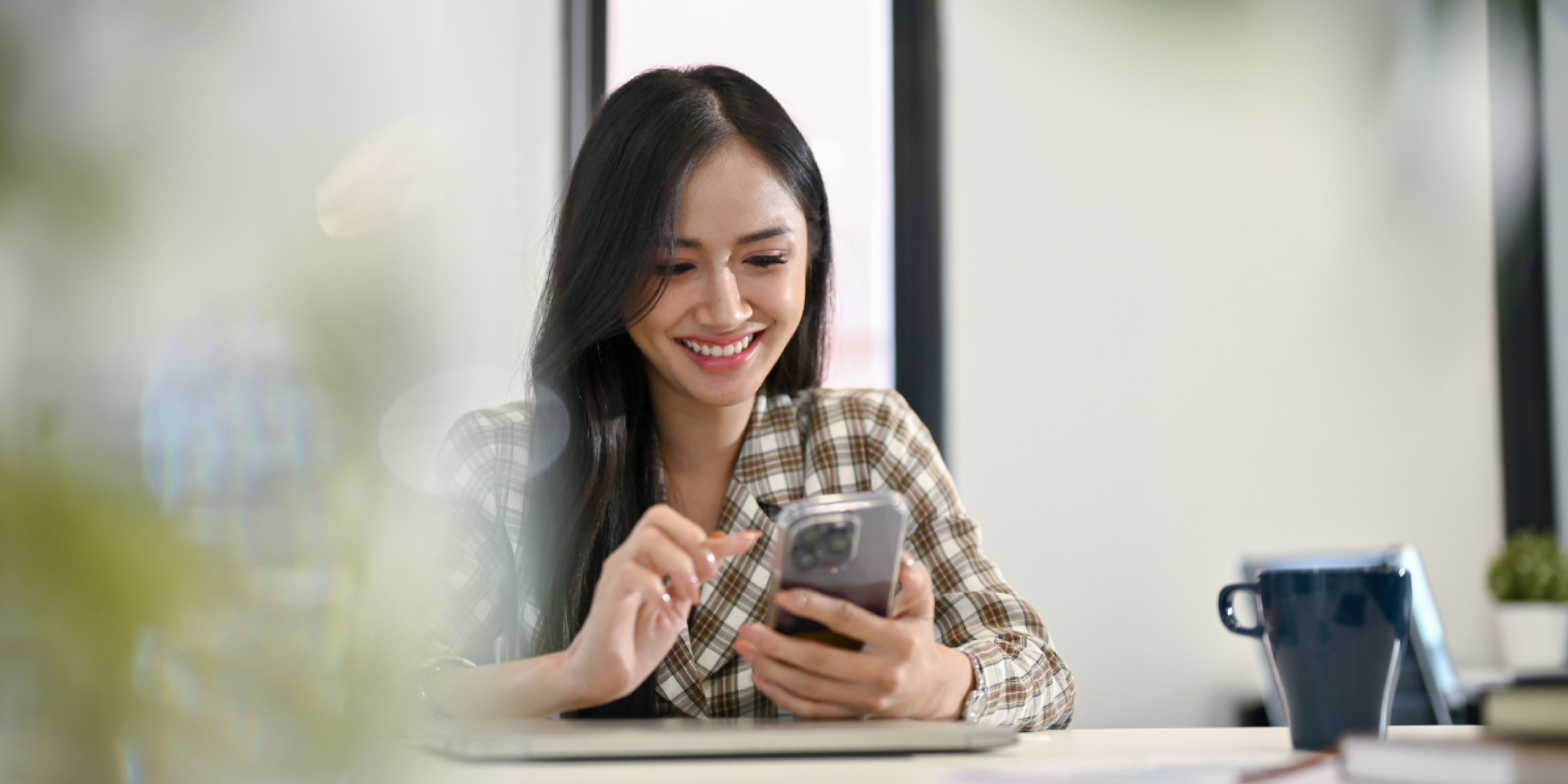 Young Professional Engaging with Smartphone in a Modern Office