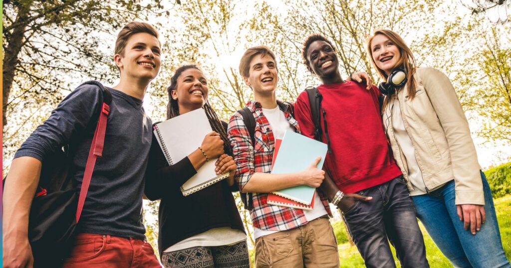 Group of college students standing outdoors holding notebooks and folders, representing student life and access to essential resources like cost-effective printing