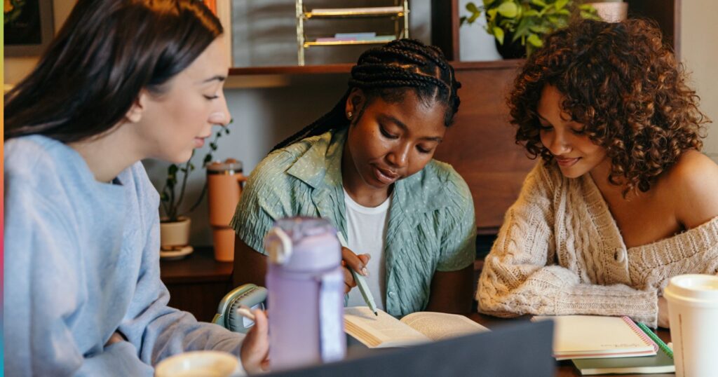 Students studying together with books and notes in a shared student housing space, representing focused academic work and responsible resource use